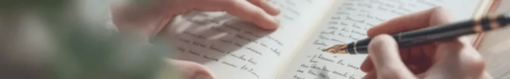 Mains tenant un stylo et écrivant des notes manuscrites dans un carnet ouvert avec arrière-plan flou